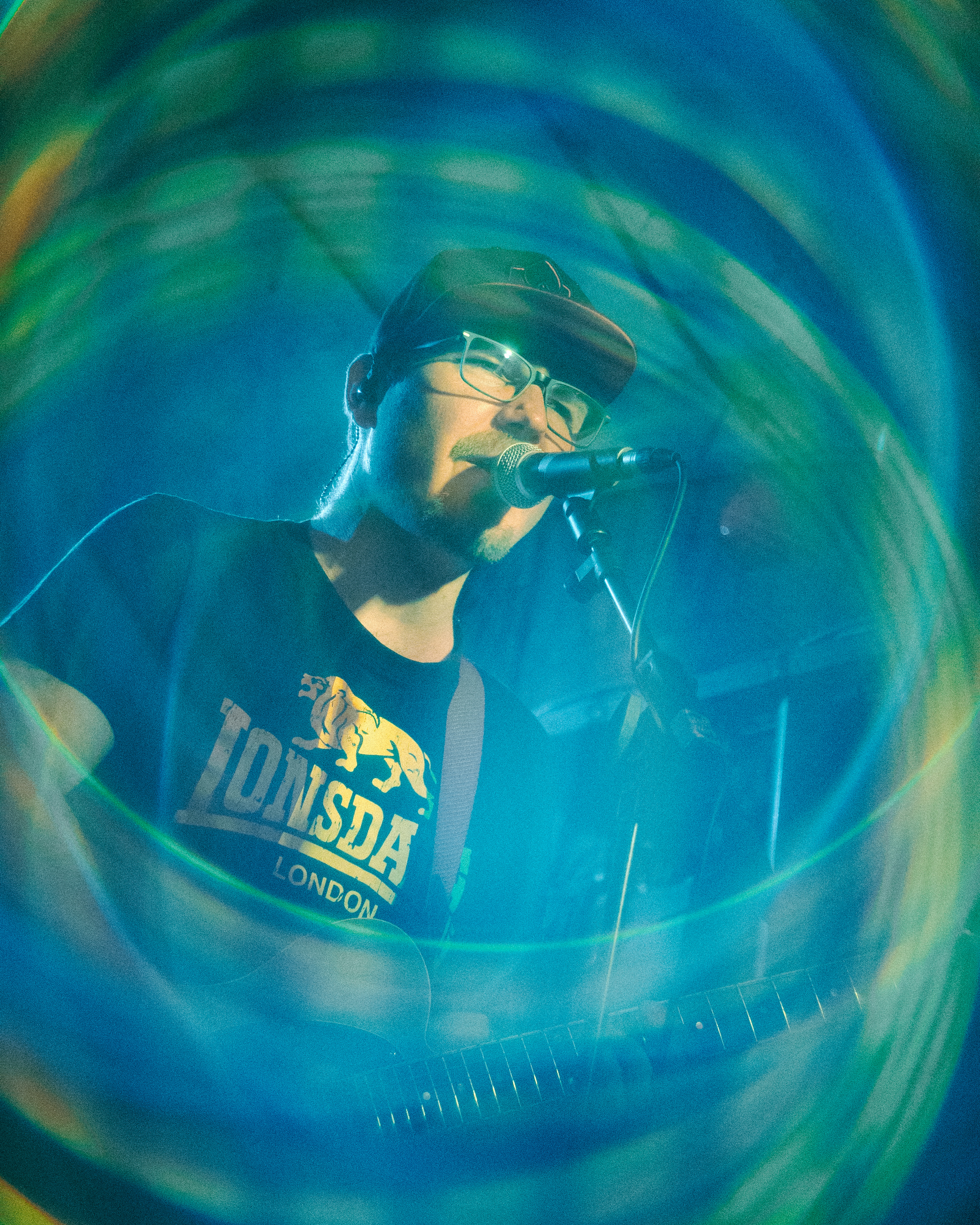 Marv spielt Gitarre im grün-blauen Bühnenlicht.
